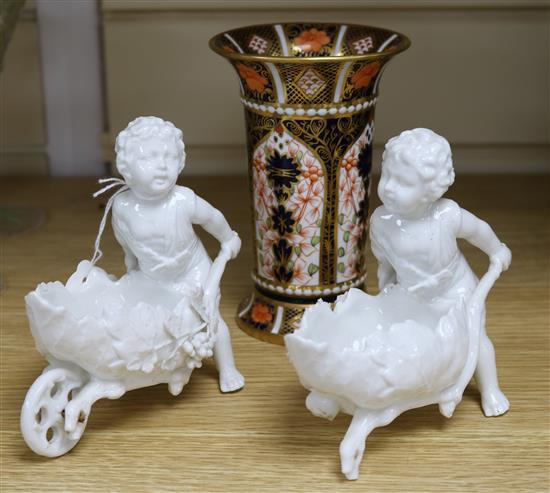 A Royal Crown Derby Old Imari pattern tapered cylindrical vase with everted rim and a pair of Meissen figures